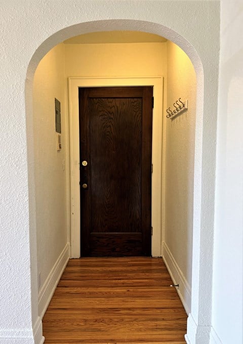 a hallway with a wooden door and an arched doorway